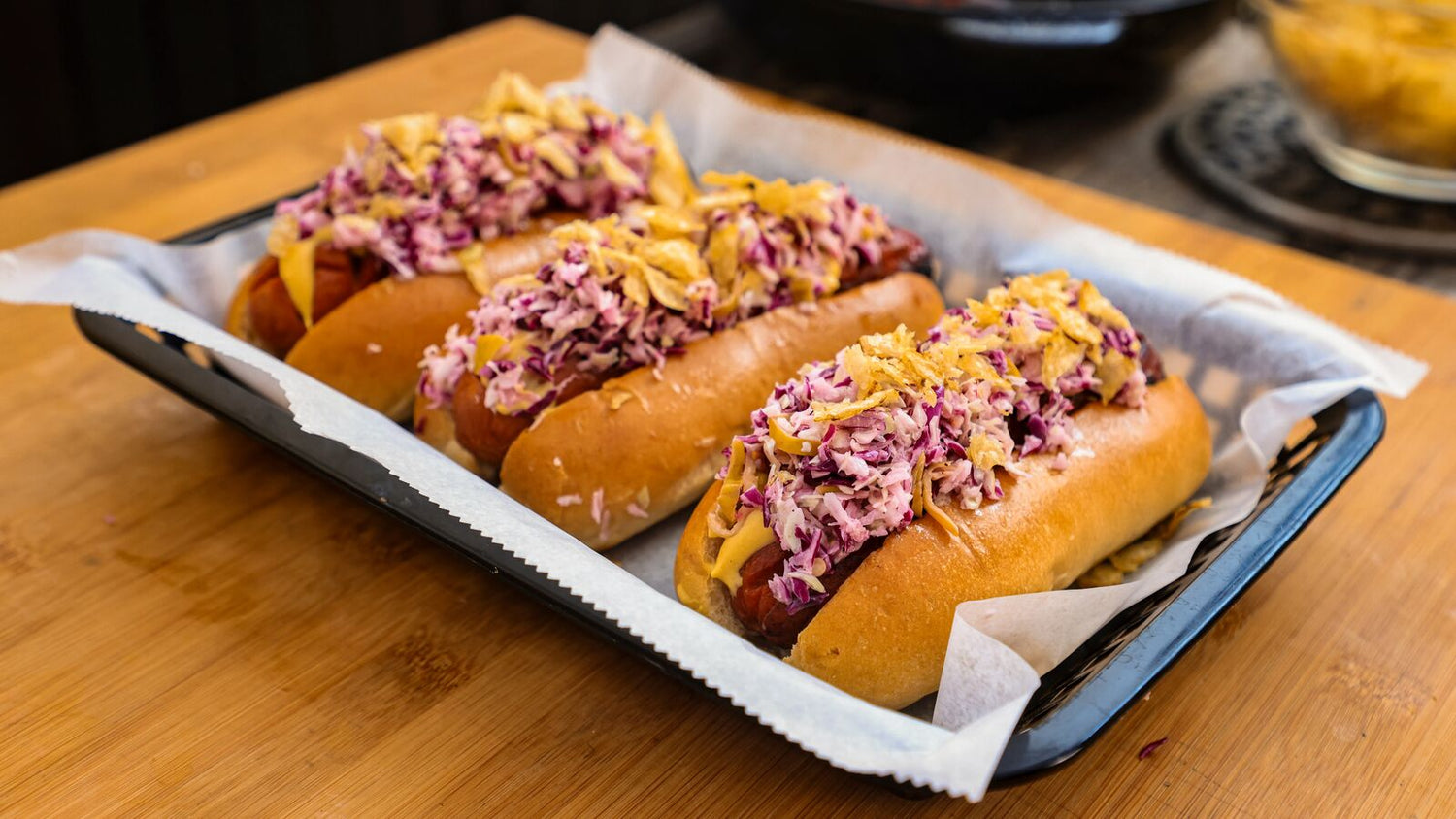 Hot dogs with coleslaw on a deli tray with parchment paper recipe poster image