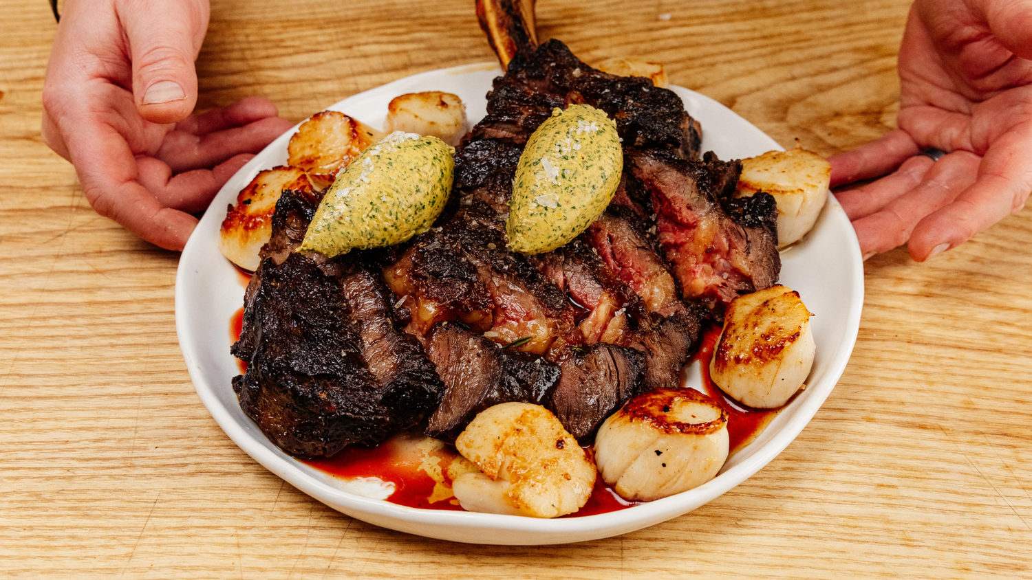 Steak and scallops with compound butter on a plate