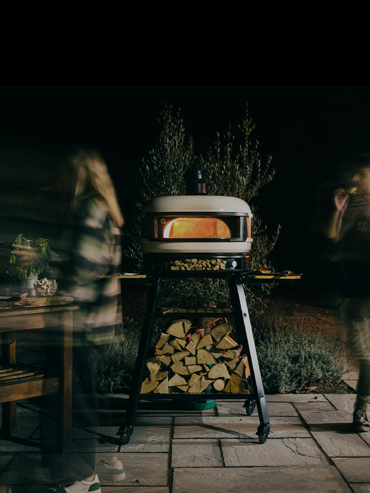 Night time pizza party with lit pizza oven 