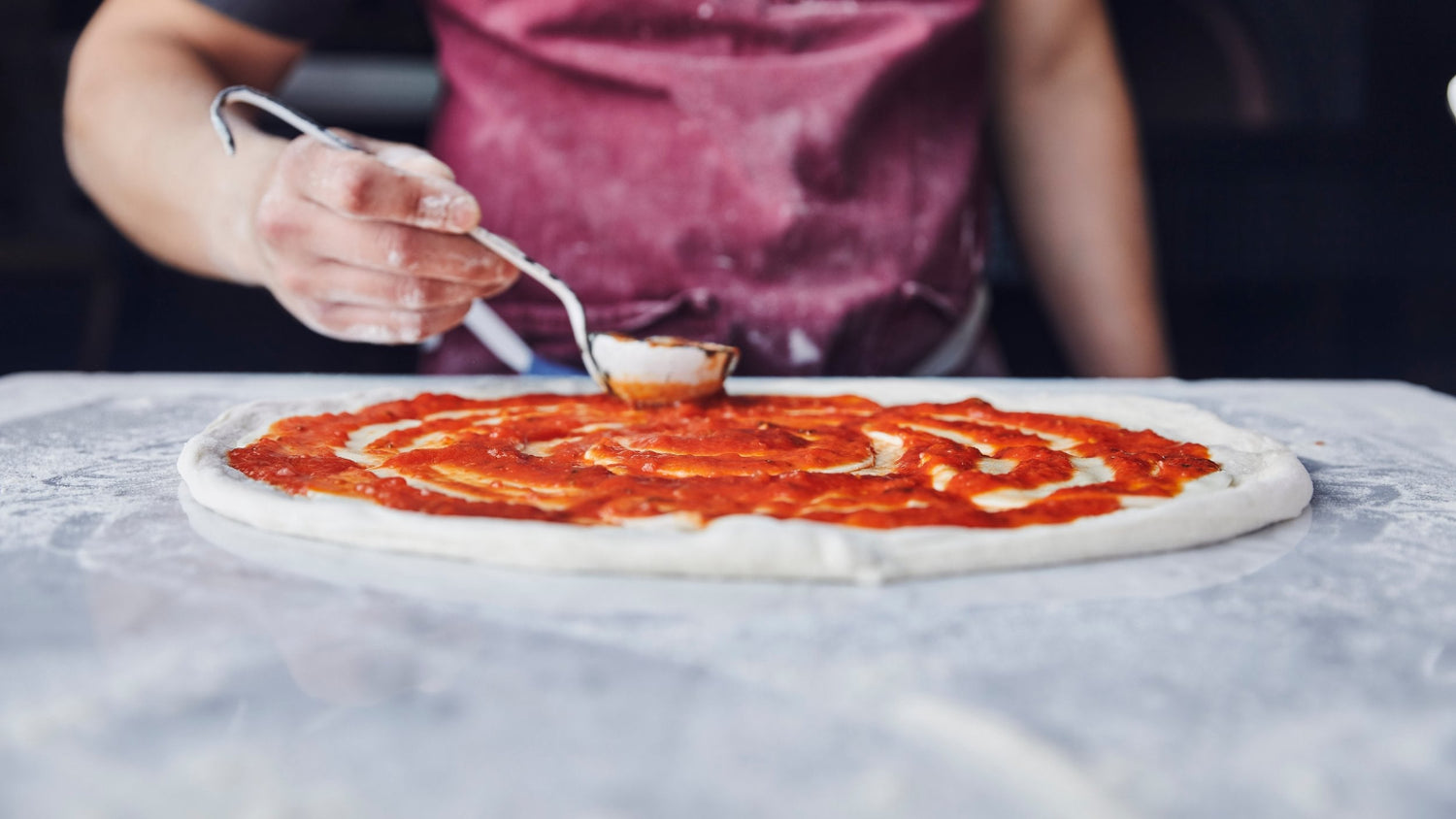 Marinara Sauce spread on pizza dough