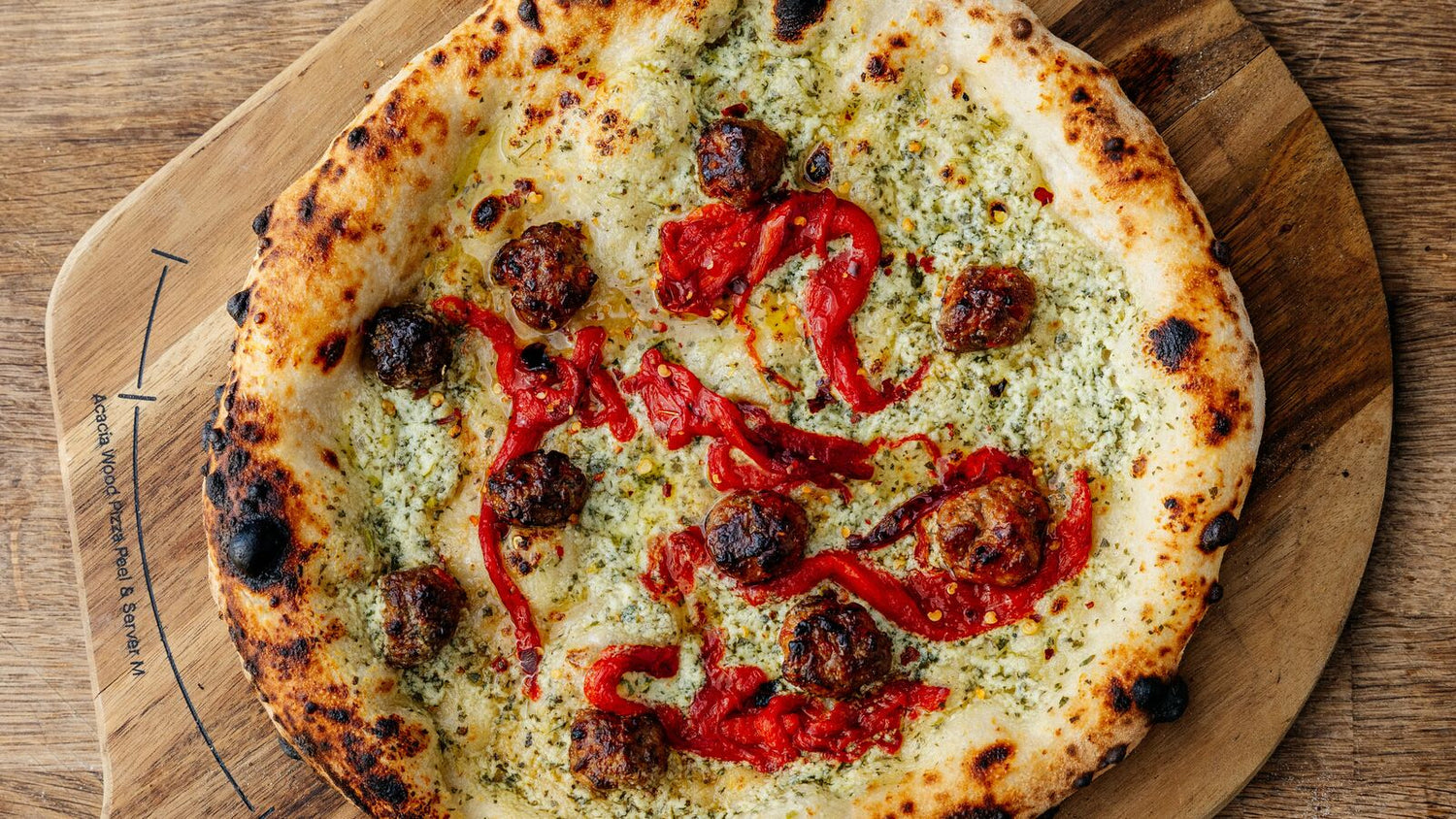 Sausage pizza on a wooden peel